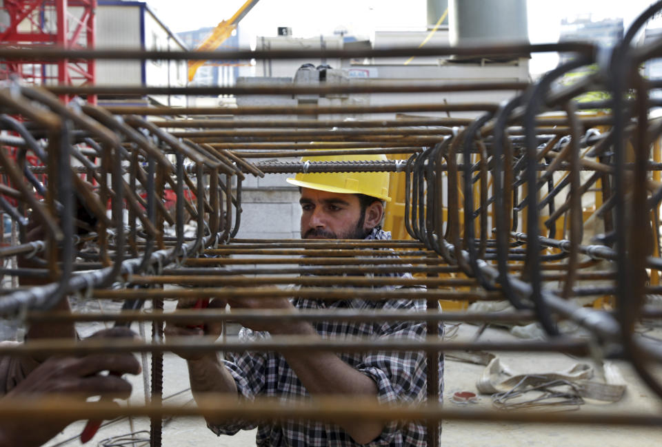 FILE- Syrian construction workers set up the foundations of a building in Beirut, Lebanon. Lebanon has suffered the consequences of neighboring Syria’s civil war, which flooded the country of 5 million with about 1 million refugees. (AP Photo/Bilal Hussein, File)