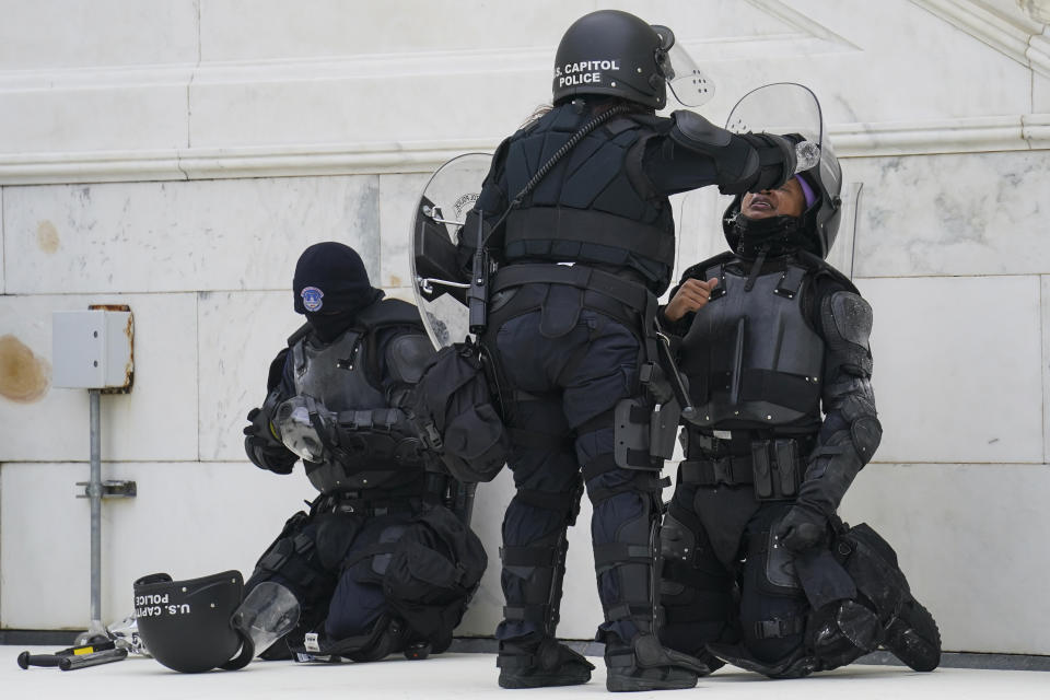 A police officer has eyes flushed with water after a confrontation with demonstrators, Wednesday, Jan. 6, 2021, at the Capitol in Washington. (AP Photo/John Minchillo)