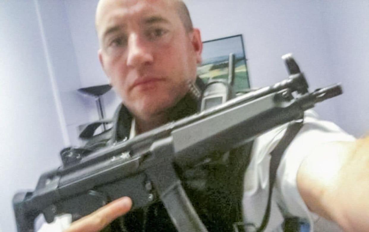 Carrick poses with police firearm - SWNS