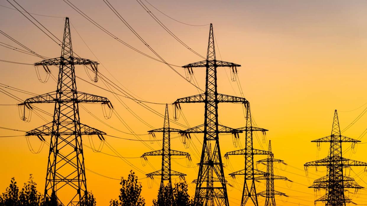 Power pylons reache into the sunset sky. Stock photo: Getty Images