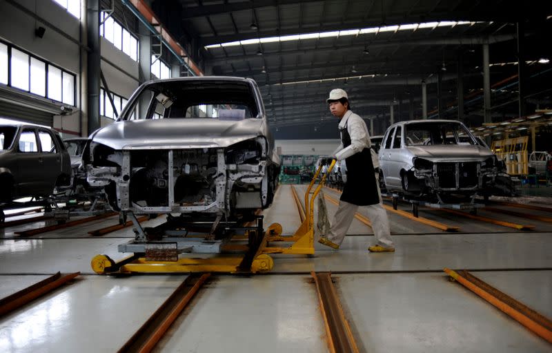 FILE PHOTO - An employee pushes a car along a Zotye Automobile Co., Ltd assembly line in Jinhua