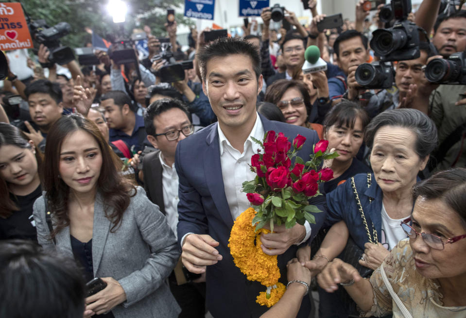 FILE - In this Nov. 20, 2019, file photo, Thanathorn Juangroongruangkit, center, leader of the anti-military Future Forward Party is surrounded by his supporters on his arrival at Constitutional Court in Bangkok, Thailand. Thailand's Constitutional Court on Tuesday, Jan. 21, 2020, acquitted the country's third-biggest political party of seeking the overthrow of the country's constitutional monarchy. (AP Photo/Gemunu Amarasinghe, File)