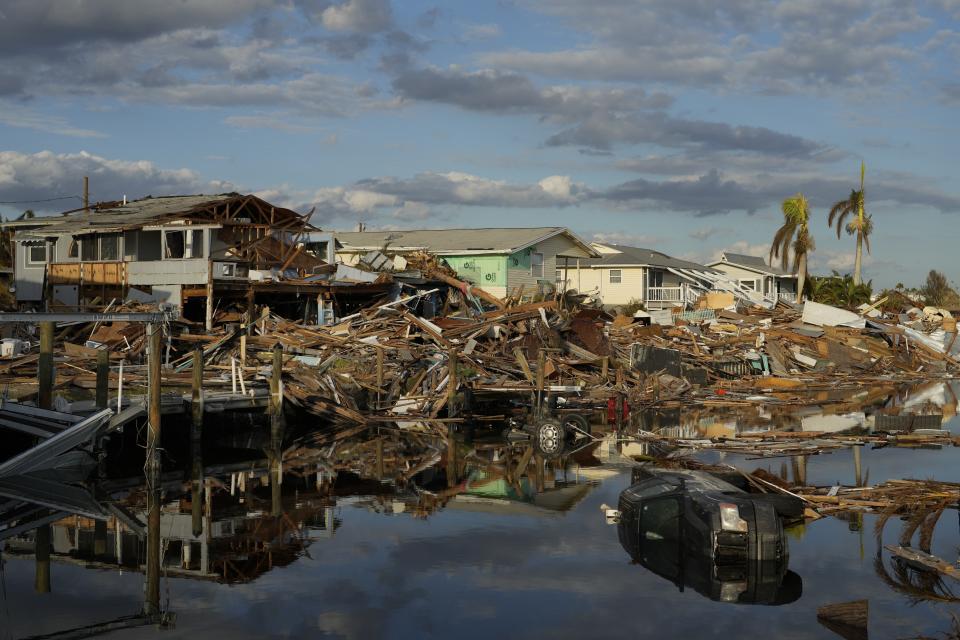 DOSSIER - Des voitures et des débris de maisons emportées par les eaux bordent un canal à Fort Myers Beach (Floride), le mercredi 5 octobre 2022, une semaine après le passage de l'ouragan Ian. Après des mois de réchauffement progressif des températures de surface de la mer dans l'océan Pacifique tropical, la NOAA a officiellement émis un avis El Nino le jeudi 8 juin 2023, en précisant que celui-ci pourrait être différent des autres. (AP Photo/Rebecca Blackwell, File)