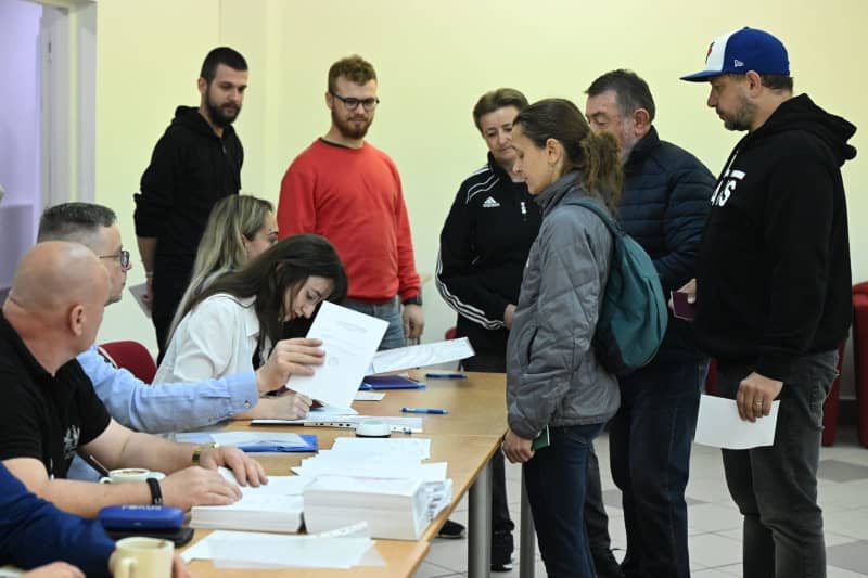 Voters receive ballot papers at a polling station in 2024 Slovakia presidential election run-off. Šálek Václav/CTK/dpa
