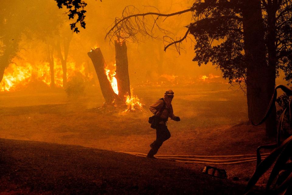 PHOTO: A firefighter runs while battling the Thompson Fire burning in Oroville, Calif., Tuesday, July 2, 2024. (Noah Berger/AP)