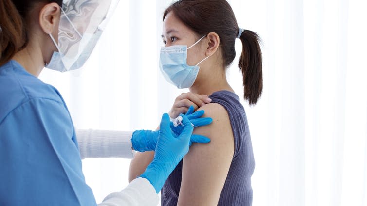 A woman being vaccinated for COVID