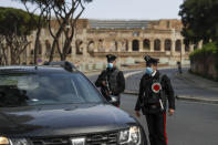 Carabinieri police officers stop a car at a road block near the Colosseum, in downtown Rome, Saturday, April 3, 2021. Italy went into lockdown on Easter weekend in its effort to battle then Covid-19 pandemic. (AP Photo/Gregorio Borgia)