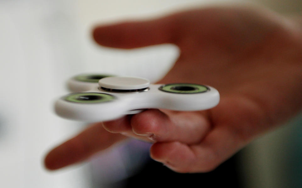 A girl plays with a fidget spinner toy in London, Britain, May 17, 2017. REUTERS/Tom Jacobs