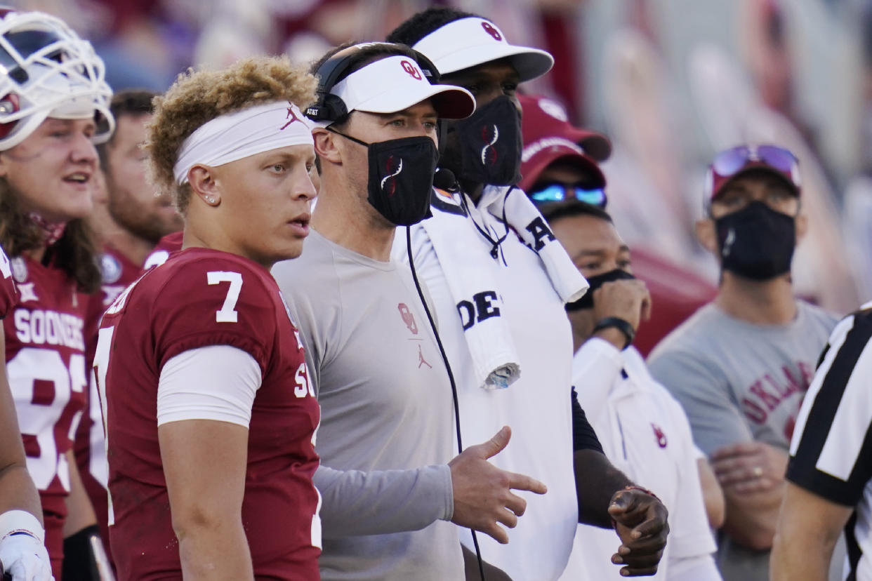 Oklahoma head coach Lincoln Riley talks with Oklahoma quarterback Spencer Rattler (7) during an NCAA college football game against Kansas in Norman, Okla., Saturday, Nov. 7, 2020. (AP Photo/Sue Ogrocki)