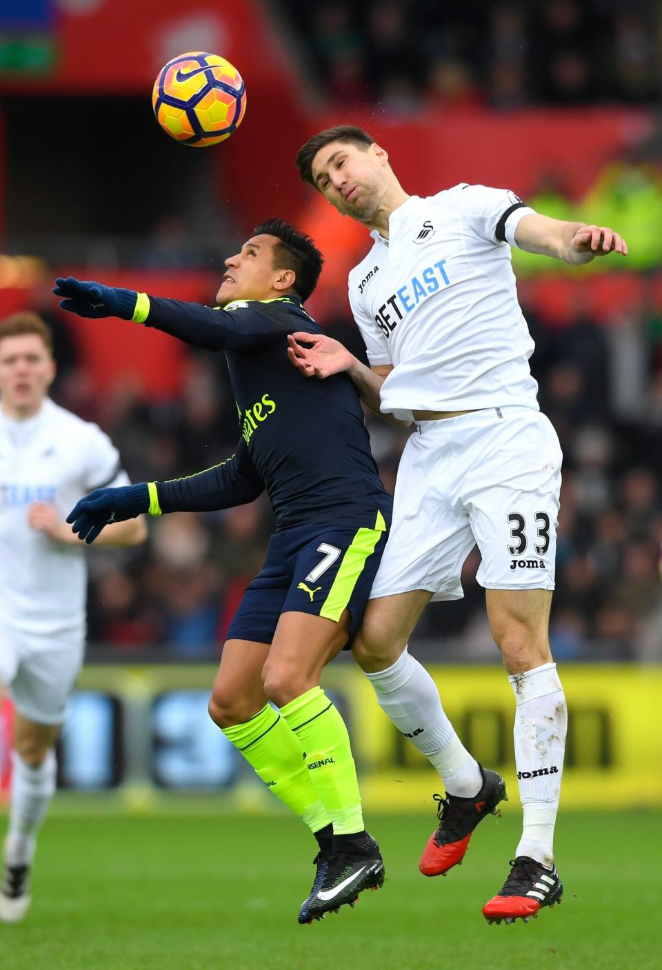 <p>Alexis Sanchez of Arsenal (L) and Federico Fernandez of Swansea City (R) battle to win a header</p>