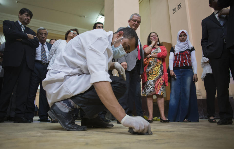 Guests watch a worker clean the floor of the Egyptian Museum in downtown Cairo, Egypt, Friday, Nov. 15, 2013. Egypt unveiled Friday an ambitious renovation project for its Cairo’s famed Egyptian Museum, in a bid to show that the Arab world’s most populous country was regaining a sense of normalcy after months of unrest. (AP Photo/Hiro Komae)