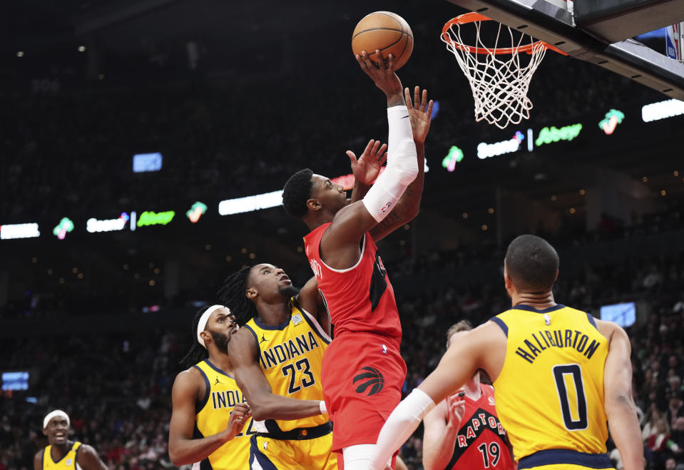 Toronto Raptors guard RJ Barrett (9) scores past Indiana Pacers forward Aaron Nesmith (23) as Pacers guard Tyrese Haliburton (0) watches during the first half of an NBA basketball game Wednesday, Feb. 14, 2024, in Toronto. (Chris Young/The Canadian Press via AP)