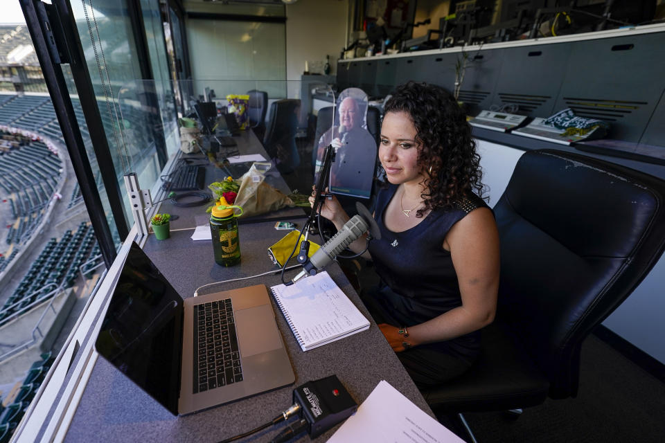 Amelia Schimmel, the new public address announcer for the Oakland Athletics, sits in the press box before a baseball game against the Houston Astros, Thursday, April 1, 2021, on opening day in Oakland, Calif. Schimmel succeeds the late Dick Callahan, who passed away in January after serving as the team's PA announcer for 15 seasons. (AP Photo/Tony Avelar)