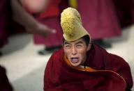 A monk reacts as he participates in a debate as part of Tibetan New Year celebrations at a temple in Langmusixiang, Sichuan Province in this February 22, 2012 file photo. REUTERS/Carlos Barria/Files