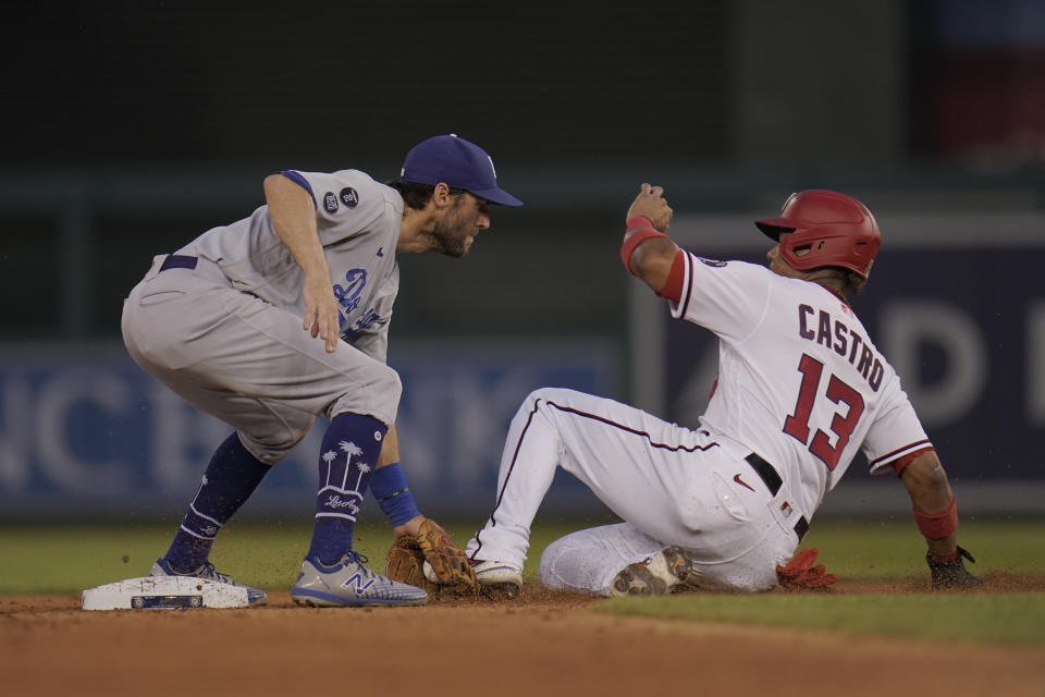 Los Angeles Dodgers shortstop Chris Taylor, left, tags out Washington Nationals' Starlin Castro, who was caught trying to steal the base by catcher Will Smith, during the fourth inning of a baseball game, Thursday, July 1, 2021, in Washington. (AP Photo/Julio Cortez)