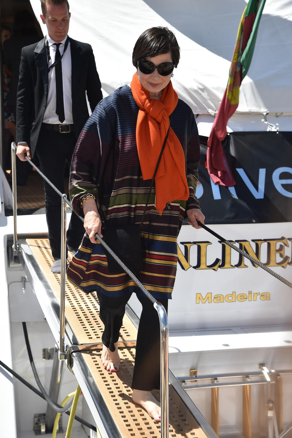 The legendary European actress/model/filmmaker disembarked the Sunliner sans shoes, but she still looked stylish wearing a striped caftan with a bright orange scarf tied around her neck.