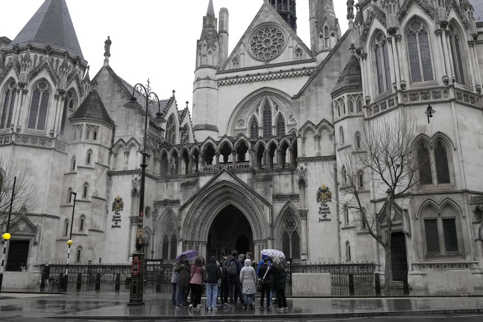 FILE - People stand outside the Royal Court of Justice in London, Friday, March 17, 2023. Judges in England and Wales have been given approval to use artificial intelligence to help writing legal opinions. The judiciary issued its first guidance last month on the use of AI. The step puts the courts at the forefront of legal systems grappling with how to regulate AI. (AP Photo/Frank Augstein, File)