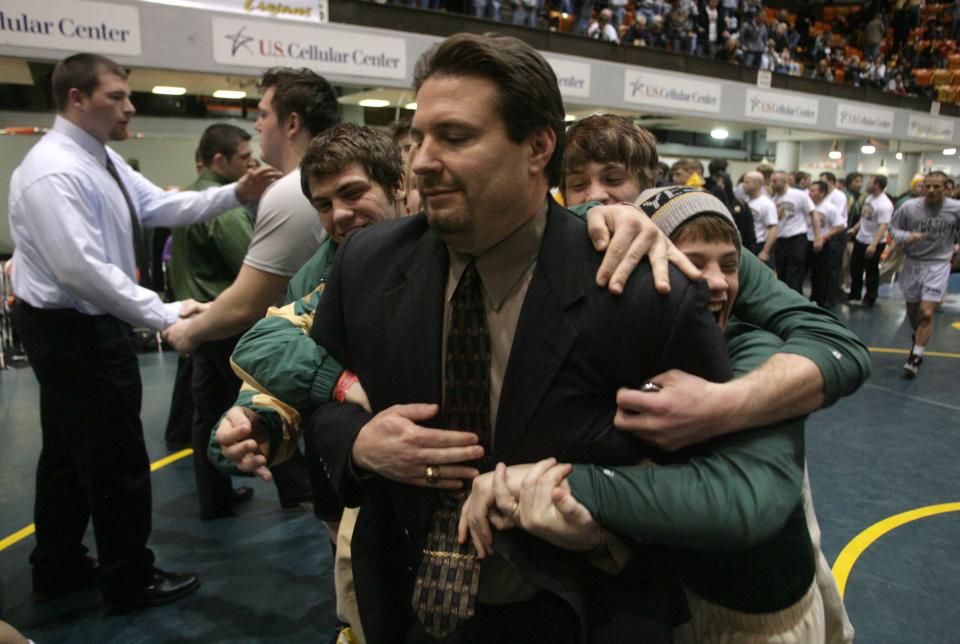 From 2011: Iowa City West High wrestlers tackle head coach Mark Reiland after the team won the Class 3A State Duals at the U.S. Cellular Center in Cedar Rapids.