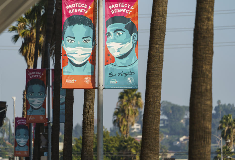 Banners advising people to wear masks against the coronavirus hang along Hollywood Boulevard in Los Angeles on Tuesday, Jan. 5, 2021. Los Angeles is the epicenter of California's surge that is expected to get worse in coming weeks when another spike is expected after people traveled or gathered for Christmas and New Year's. (AP Photo/Damian Dovarganes)