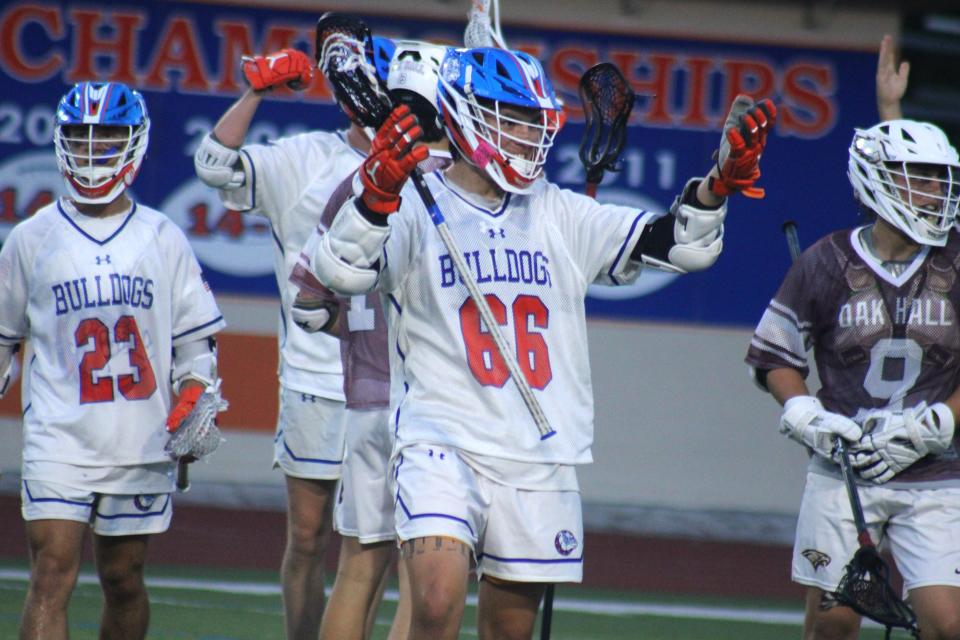 Bolles attacker Daylin John-Hill (66) celebrates a goal against Gainesville Oak Hall with teammates during Saturday's FHSAA Region 1-1A high school boys lacrosse final.