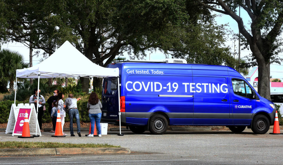 People collect swab samples from their mouths at a walk-up...