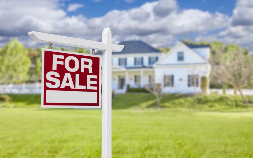 A "For Sale" sign is displayed in front of a house with a large lawn