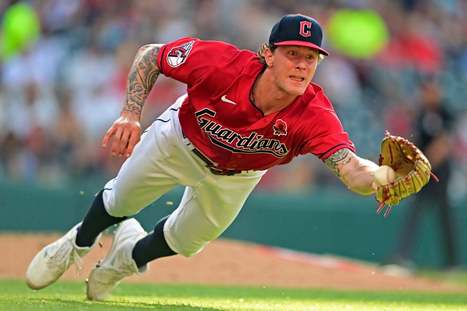 Guardians starting pitcher Zach Plesac dives for a ball hit by Kansas City Royals outfielder Andrew Benintendi in the third inning of a recent game. [David Dermer/Associated Press]