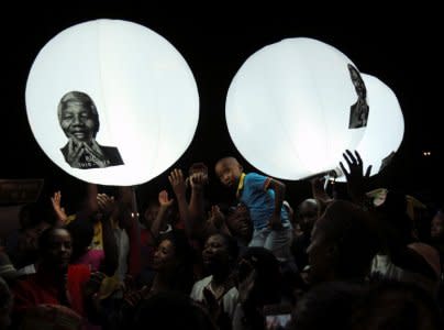 FILE PHOTO: A boy looks on in front of balloons bearing a picture of former South African President Nelson Mandela on Vilakazi Street in Soweto, South Africa, December 7, 2013. REUTERS/Siphiwe Sibeko/File Foto