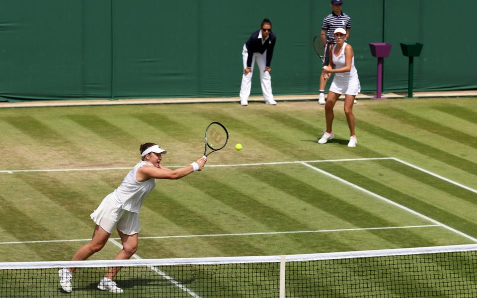 Jelena Ostapenko of Latvia (L) and partner Lyudmyla Kichenok of Ukraine play a backhand against Heather Watson of Great Britain and partner Harriet Dart of Great Britain during their Women's Doubles Third Round match on day eight of The Championships Wimbledon 2022 at All England Lawn Tennis and Croquet Club on July 04, 2022 in London, England - Clive Brunskill/Getty Images Europe