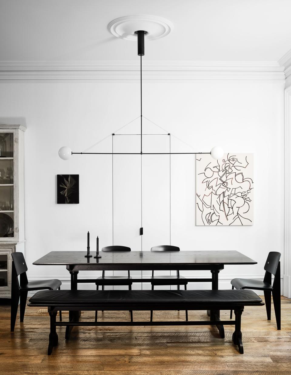 Jean Prouvé chairs surround the dining area’s matter made table; Michael Anastassiades chandelier; art by Chris Duncan (left) and Zio Ziegler (right); Farrow & Ball wall paint.