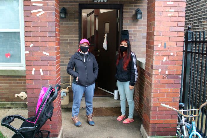 En esta foto del 14 de mayo de 2020, Erendira Martínez y su hija están paradas frente a su casa en el vecindario Little Village de Chicago. El barrio Little Village de Chicago es conocido por ser el corazón de la cultura mexicana en la ciudad. También se encuentra en el código postal con una de las tasas más altas de casos positivos de coronavirus en la ciudad. Tanto Martínez como su hija, junto con el esposo de Martínez, dieron positivo para en COVID-19. Todos se han recuperado. (Foto AP/Noreen Nasir)