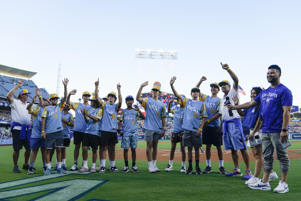 El Segundo players wave during a ceremony honoring the team's victory in the Little League World Series, before a baseball game between the Los Angeles Dodgers and the Arizona Diamondbacks, Tuesday, Aug. 29, 2023, in Los Angeles. (AP Photo/Ryan Sun)