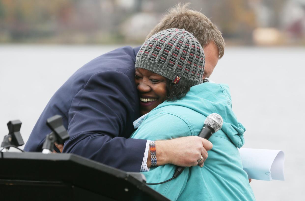 Dan Rice, CEO of Ohio and Erie Canalway Coalition, hugs Summit Lake resident Sandra Saulsberry after she speaks Wednesday at a news conference about the lake's renewal project.