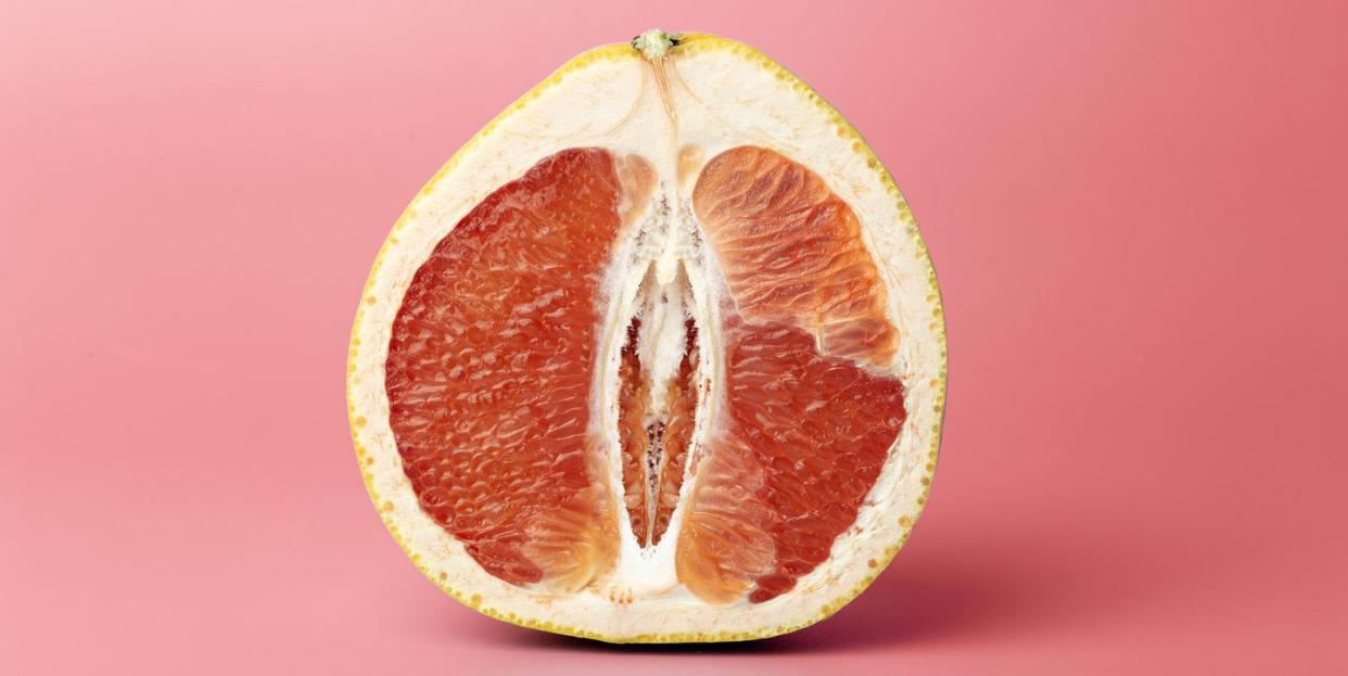 half a juicy grapefruit close up on a colored background