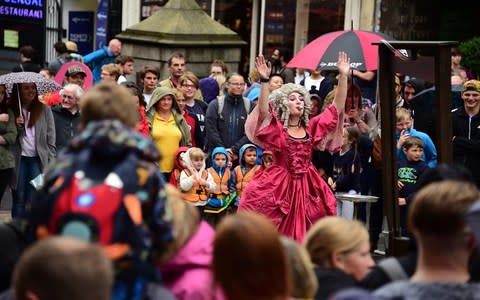 A crowd gathers around a street performer on the Royal Mile - Credit: Getty