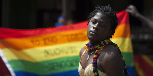 A transgender Ugandan poses in front of a rainbow flag during the 3rd Annual Lesbian, Gay, Bisexual and Transgender (LGBT) Pride celebrations in Entebbe, Uganda, Saturday, Aug. 9, 2014.  Scores of Ugandan homosexuals and their supporters are holding a gay pride parade on a beach in the lakeside town of Entebbe. The parade is their first public event since a Ugandan court invalidated an anti-gay law that was widely condemned by some Western governments and rights watchdogs. (AP Photo/Rebecca Vassie) (Photo: )