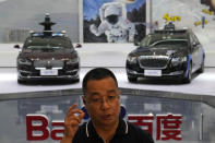 Wei Dong, vice president of Baidu's Intelligent Driving Group, speaks near a display showing the various prototypes of the self-driving taxi developed by tech giant Baidu Inc. on June 14, 2022, in Beijing. Baidu Inc. is China's highest-profile competitor in a multibillion-dollar race with Alphabet Inc.'s Waymo and General Motors Co.'s Cruise to create self-driving cars. (AP Photo/Ng Han Guan)