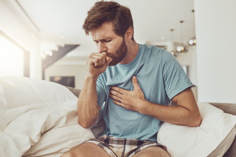 A man on a sofa feeling unwell