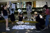 Employees of a recruitment platform promote their company at a stall they set up by a street, near an office complex in Beijing's business district