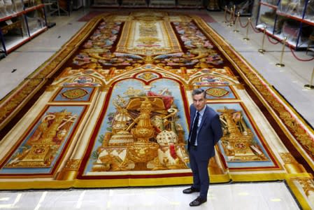 Herve Lemoine, head of the Mobilier National and the Gobelins Manufactury, poses in front of the 19th century choir carpet of Notre-Dame de Paris Cathedral,