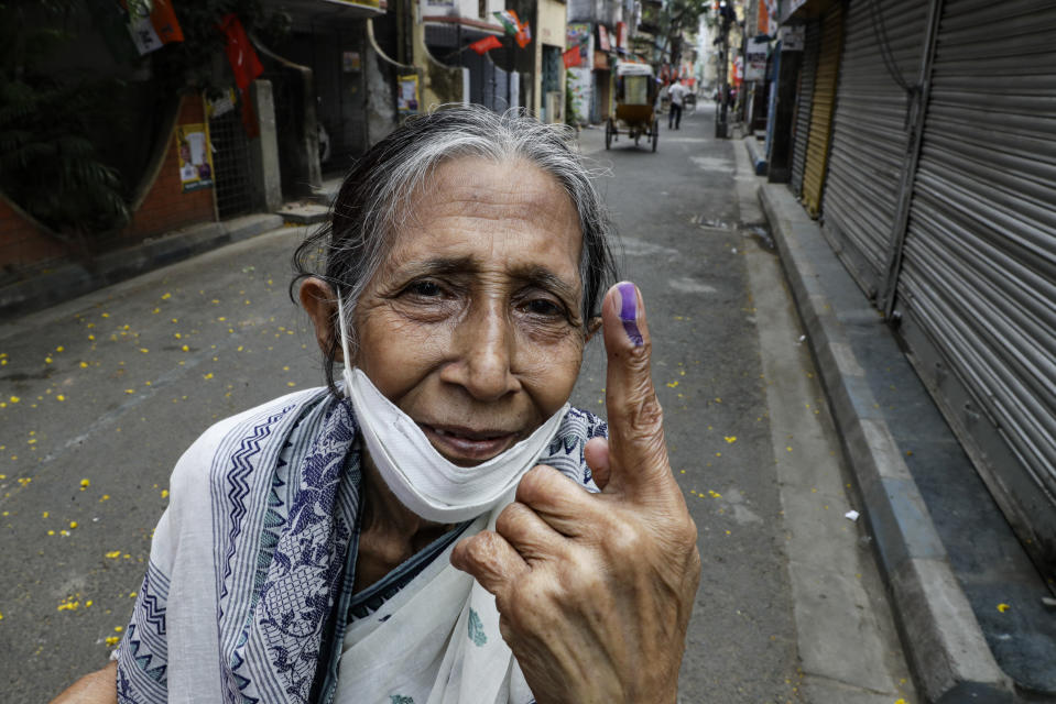 Bani Dasgupta, 75, displays the indelible ink mark after casting the vote during the fourth phase of West Bengal state elections in Kolkata, India, Saturday, April 10, 2021. (AP Photo/Bikas Das)