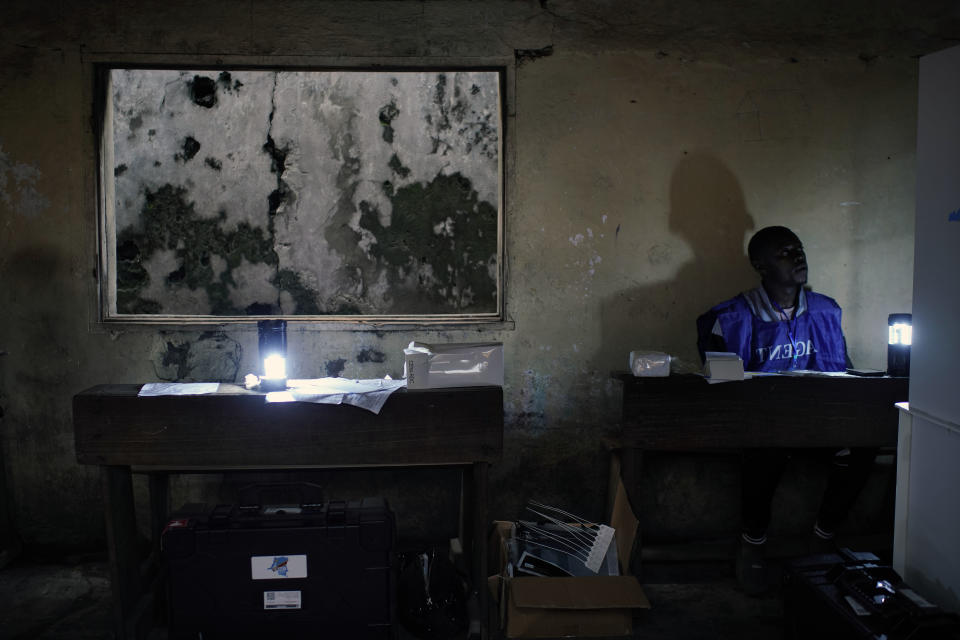 Election volunteers who have been waiting over 12 hours to start the election process at the Les Anges primary school in Kinshasa, Congo. Sunday Dec. 30, 2018, wait for the voting station to open. The voting process was delayed when angry voters burned six voting machines and ballots mid-day, angered by the fact that the registrations lists had not arrived. Replacement machines had to be brought in, and voting started at nightfall, 12 hours late. Forty million voters are registered for a presidential race plagued by years of delay and persistent rumors of lack of preparation. (AP Photo/Jerome Delay)