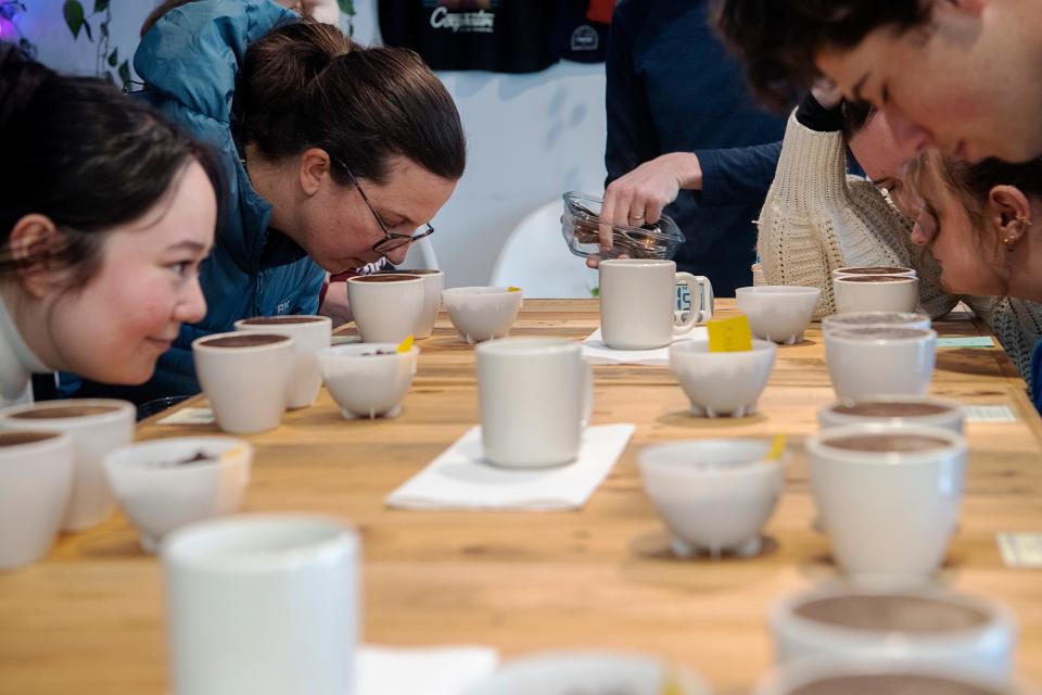 Guests of Cooperative Coffee Roasters smell the aroma of multiple coffees during a cupping event, January 19, 2024.
