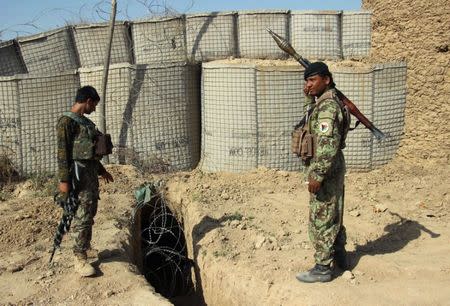 Afghan National Army (ANA) soldiers stand next to an outpost where 12 soldiers were killed by their comrades in the northern city of Kunduz, Afghanistan September 27, 2016. REUTERS/NasIr Wakif