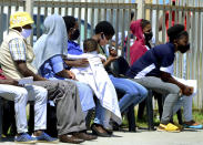 Without practicing social distancing, people queue outside home affairs offices for document in Port Elizabeth, South Africa, Friday, Nov. 13, 2020. The Eastern Cape Province is seeing a surge in cases of coronavirus and has recorded the highest number of COVID-19-related deaths in the country. (AP Photo/Theo Jeptha)