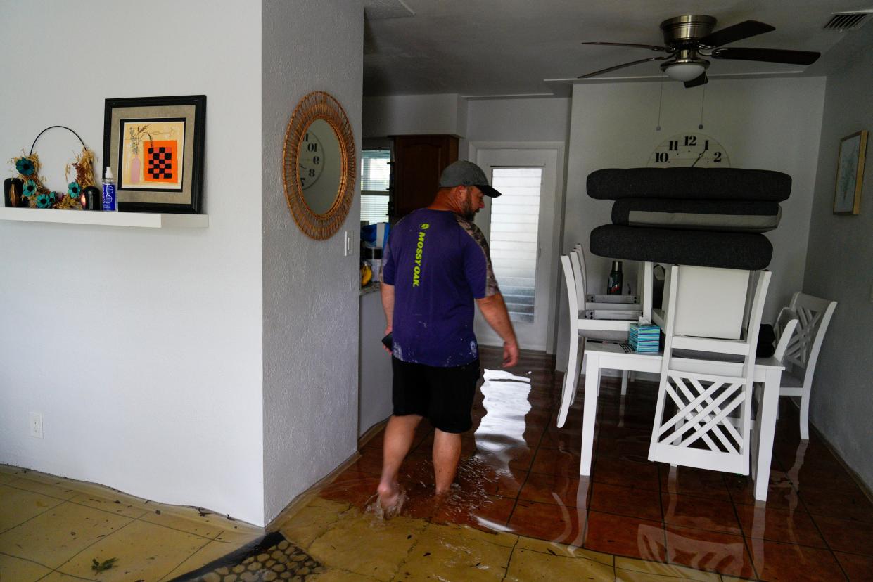Chad Hinchman, 40, walks through one of his rental Airbnb properties on Hibiscus Avenue South, Pasadena, which flooded overnight (AP)