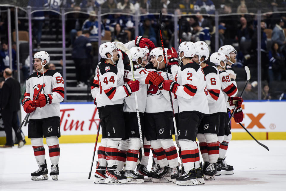 The New Jersey Devils celebrate after center Yegor Sharangovich (17) scored against the Toronto Maple Leafs during overtime in an NHL hockey game Thursday, Nov. 17, 2022, in Toronto. (Christopher Katsarov/The Canadian Press via AP)