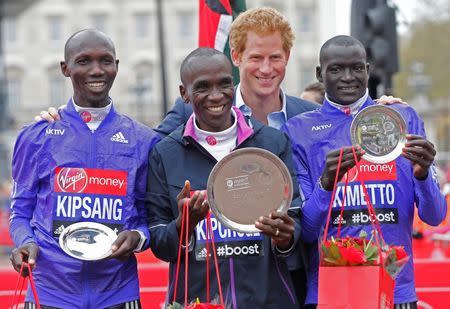 Athletics - Virgin Money London Marathon - London - 26/4/15 Kenya's Eliud Kipchoge (1st), Kenya's Wilson Kipsang (2nd) and Kenya's Dennis Kimetto (3rd) pose with their trophies and Prince Harry after the Men's Elite race Reuters / Suzanne Plunkett Livepic