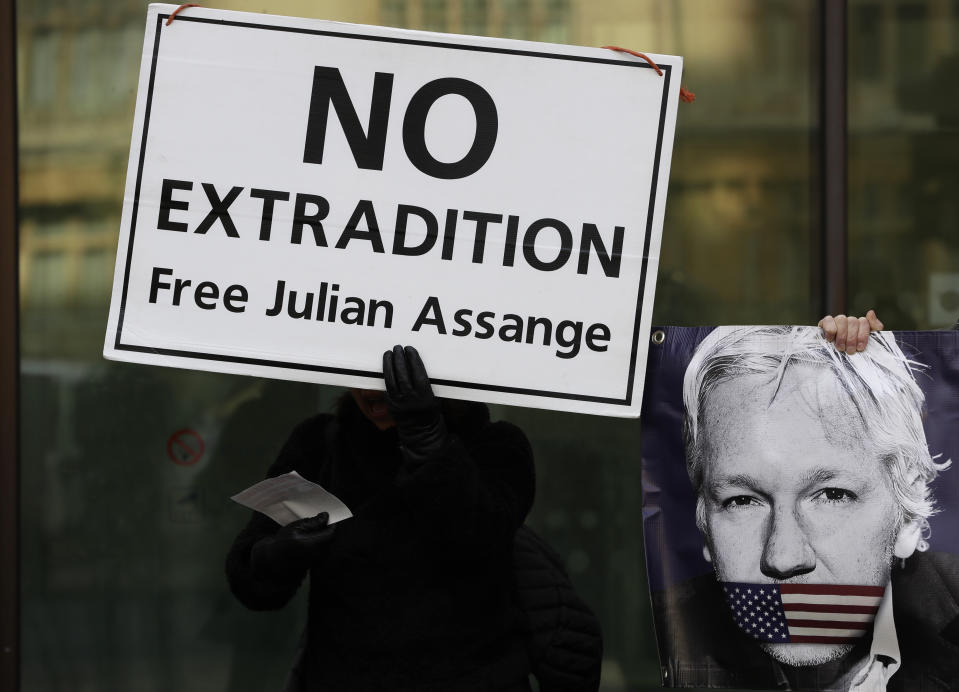 Protesters hold banners outside Westminster Magistrates Court in London, where Julian Assange is due to appear, Monday, Jan. 13, 2020. Protesters will be insisting that Assange should not be extradited to the US for his reporting of the Iraq and Afghanistan war. They insist he will not face a fair trial in the United States where the charges against him could result in imprisonment for 175 years. Assange will be transported from Belmarsh high-security prison. (AP Photo/Kirsty Wigglesworth)