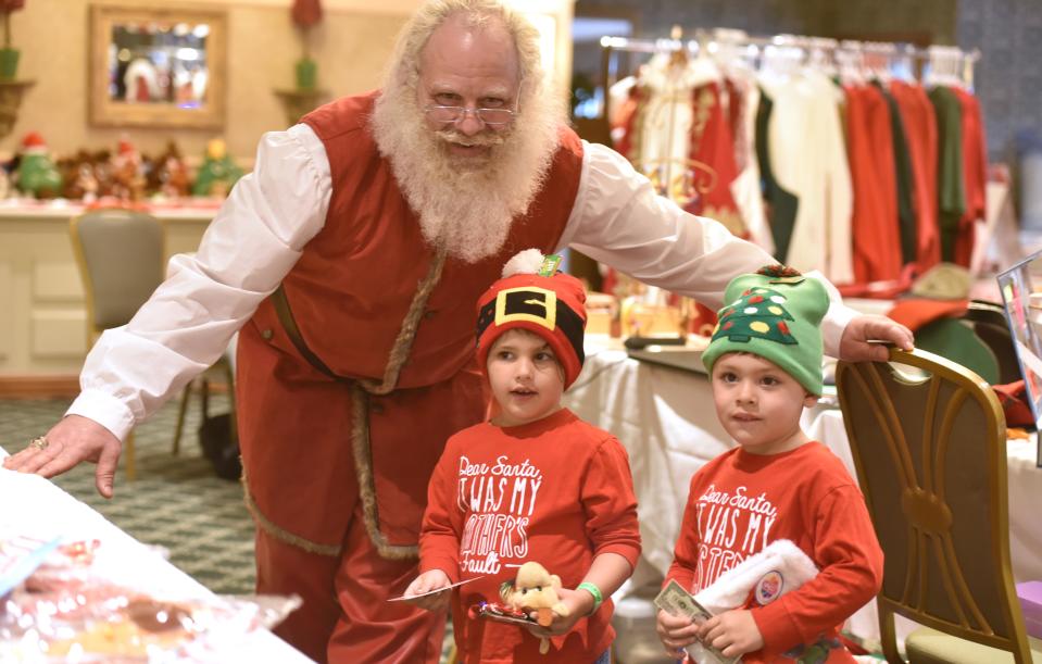 Twins Maeve and James Paraquay visit with Santa Paul Agrusti from New Jersey in his workshop during an afternoon of fun during the North East Santa Claus Gathering in 2019.